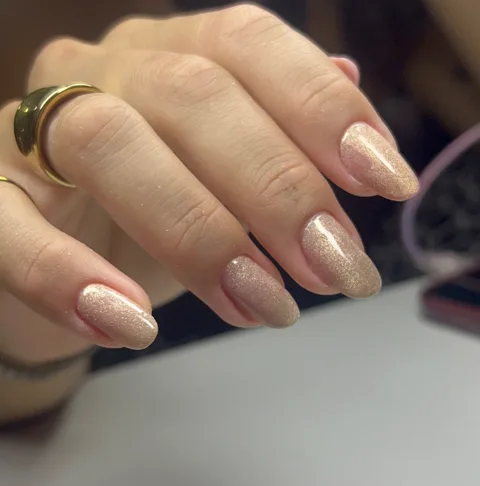 Unhas amendoadas em nude dourado com glitter fino